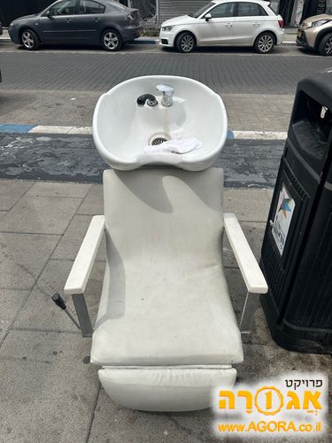 כיסא עם כיור למספרה בצבע לבן נמצא ברחוב
