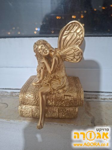 פסלון של ילדה יושבת על ספרים